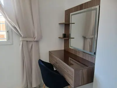a dressing table with a mirror and a blue chair at Cozy two bedroom apartment in Meknès