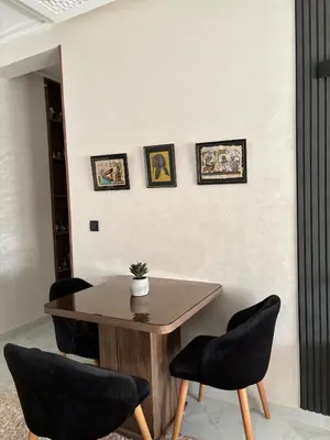 a dining room with a wooden table and chairs at Cozy two bedroom apartment in Meknès