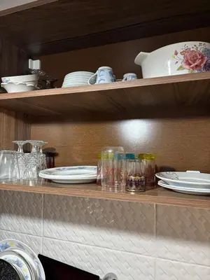 a shelf with plates and glasses and dishes on it at Cozy two bedroom apartment in Meknès