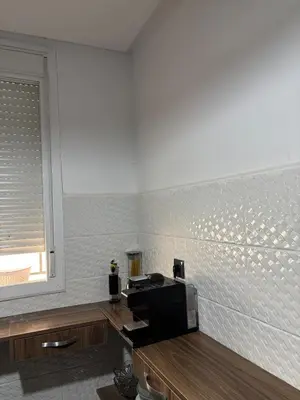 a kitchen with a microwave on a counter with a window at Cozy two bedroom apartment in Meknès