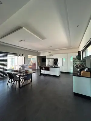 a large living room with a table and a kitchen at Villa Prestige in Najem