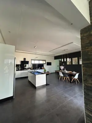 a kitchen and living room with a table and chairs at Villa Prestige in Najem