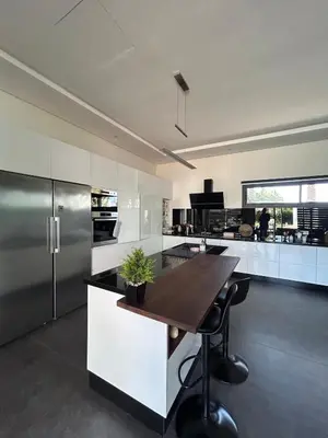 a kitchen with a wooden table and a refrigerator at Villa Prestige in Najem
