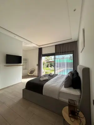 a bedroom with a large bed and a large window at Villa Prestige in Najem