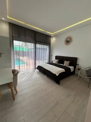 a bedroom with a bed and a large window at Villa Prestige in Najem