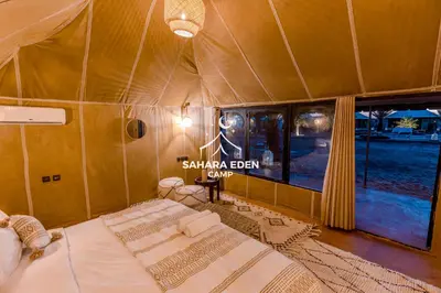 a bedroom with two beds in a tent at Sahara Eden Camp in Merzouga