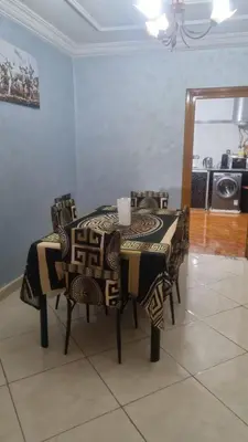a dining room table and chairs with a table and a mirror at Très bel appartement spacieux in Taza