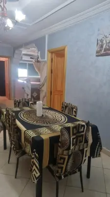 a dining room table and chairs with a black and white table at Très bel appartement spacieux in Taza