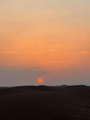 a sunset in the desert with the sun in the sky at Desert tours&trips in Zagora