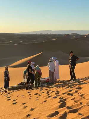 a group of people standing in the desert at Desert tours&trips in Zagora