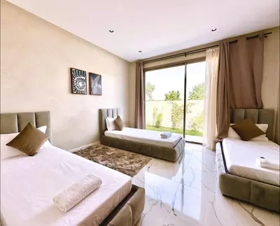 two beds in a room with a large window at Villa shams Marrakech , Private Pool and Hammam in Azib Oulad Lâdem