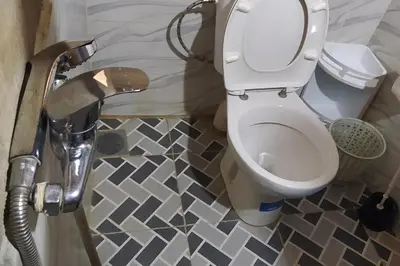a bathroom with a toilet and a tile floor at Desert house in Merzouga