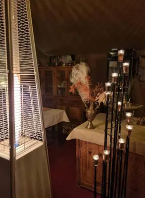 a room with a table and a vase with flowers at Desert Pearl Camp Merzouga in Merzouga