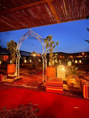 a room with an arch and a red carpet at Desert Pearl Camp Merzouga in Merzouga