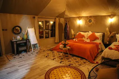 a bedroom with a bed in a tent at Desert Pearl Camp Merzouga in Merzouga