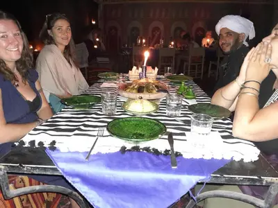 a group of people sitting around a table with a candle at Auberge chez hammadi