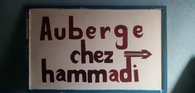 a sign on a wall that readsilagehydehyde the hamadan at Auberge chez hammadi
