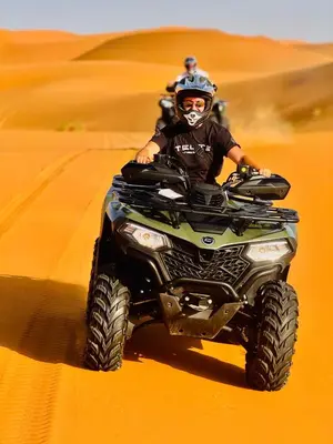 a man riding a quad bike in the desert at Nights luxury camp in Merzouga