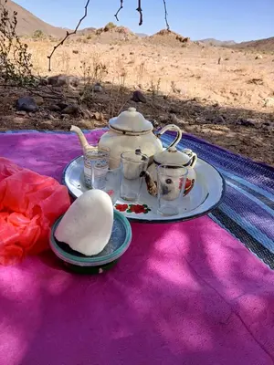 a table with a tea set on a purple blanket at Agoudim Nikhartan in Tinerhir