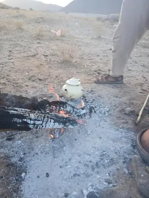 a tea pot sitting over a fire in the desert at Agoudim Nikhartan in Tinerhir