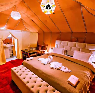 a bedroom with a large bed in a tent at Merzouga Stellar Camp in Merzouga
