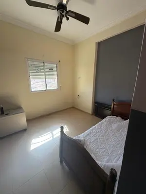 a bedroom with a bed and a ceiling fan at Apparemment à 100 mètres du complexe de fes in Fès