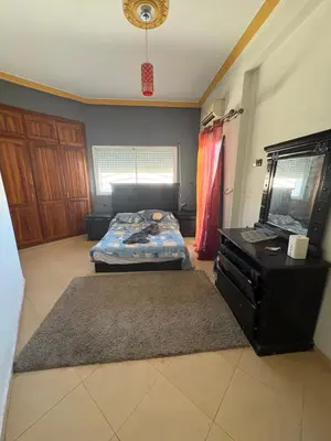 a bedroom with two beds and a dresser in it at Apparemment à 100 mètres du complexe de fes in Fès