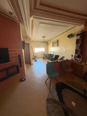 a living room with a table and chairs at Apparemment à 100 mètres du complexe de fes in Fès
