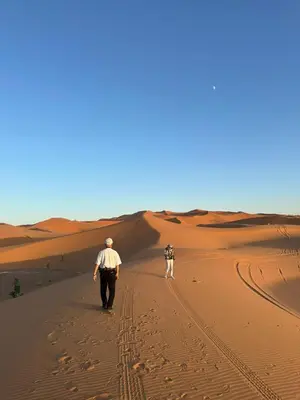 two people walking through the desert at Connect Nomad - Luxury Camp Merzouga in Merzouga