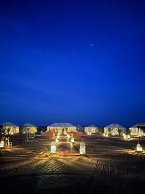 a parking lot at night with lights and tents at Connect Nomad - Luxury Camp Merzouga in Merzouga