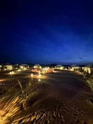 a view of a beach at night with lights at Connect Nomad - Luxury Camp Merzouga in Merzouga