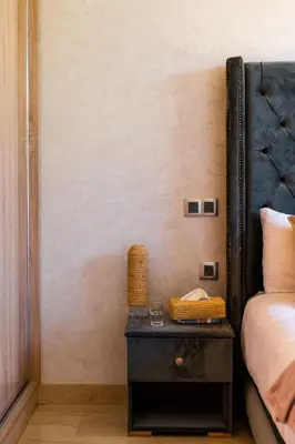 a bedroom with a bed and a table with a night stand at Villa Dar E'Zwinna in Marrakech