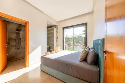 a master bedroom with a bed and a shower at Villa Dar E'Zwinna in Marrakech