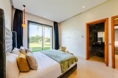 a bedroom with a bed and a large window at Villa Dar E'Zwinna in Marrakech