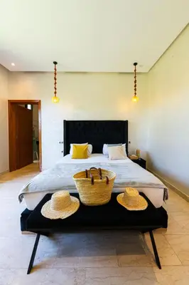 a bedroom with a bed with two straw hats on it at Villa Dar E'Zwinna in Marrakech