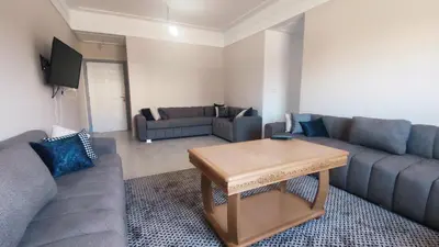 a living room with a couch and a coffee table at Bright & Calm Apartment in Riad Toulal in Meknès