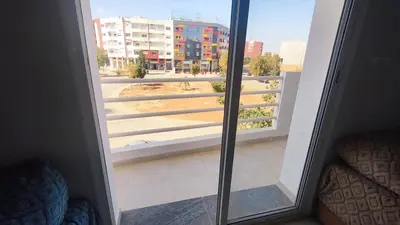 a door to a balcony with a view of a building at Bright & Calm Apartment in Riad Toulal in Meknès