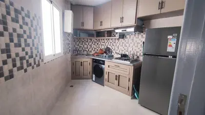 a small kitchen with a stove and a refrigerator at Bright & Calm Apartment in Riad Toulal in Meknès