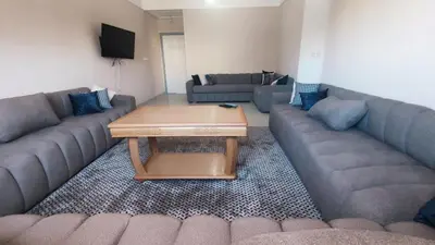 a living room with two couches and a coffee table at Bright & Calm Apartment in Riad Toulal in Meknès
