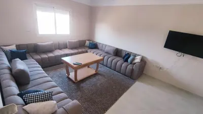 a living room with a couch and a table at Bright & Calm Apartment in Riad Toulal in Meknès