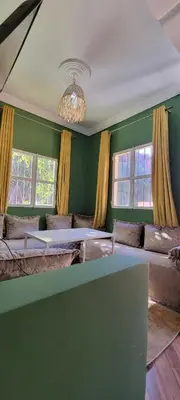 a living room with green walls and couches and windows at Green Ourika Haven Relax Among Mountains Nature