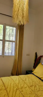 a bedroom with a yellow bed and a window at Green Ourika Haven Relax Among Mountains Nature