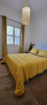 a bedroom with a large yellow bed with a chandelier at Green Ourika Haven Relax Among Mountains Nature