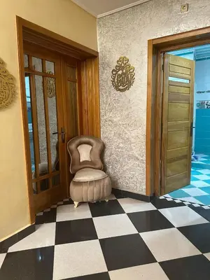 a chair sitting in a room with a checkered floor at la perle de fes in Fès