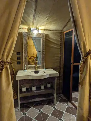 a bathroom with a sink and a mirror at moroccan izem camp in Merzouga