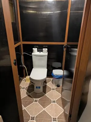 a small bathroom with a toilet and a tiled floor at moroccan izem camp in Merzouga