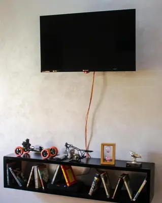 a black shelf with a flat screen tv on a wall at Oasis apartment in Ouarzazate