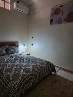a bedroom with a bed and a lamp in it at Oasis apartment in Ouarzazate