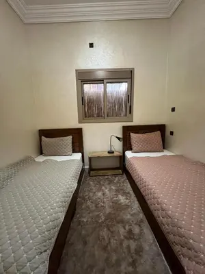 a room with two beds and a window at Oasis apartment in Ouarzazate