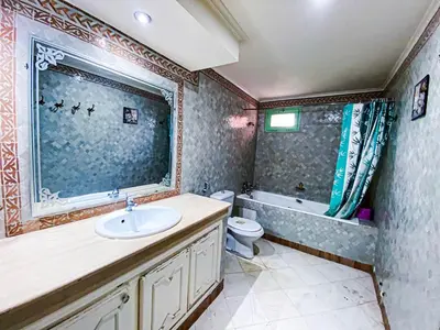 a bathroom with a sink and a tub and a toilet at Appartement d'orient centre ville in Oulad Akkou
